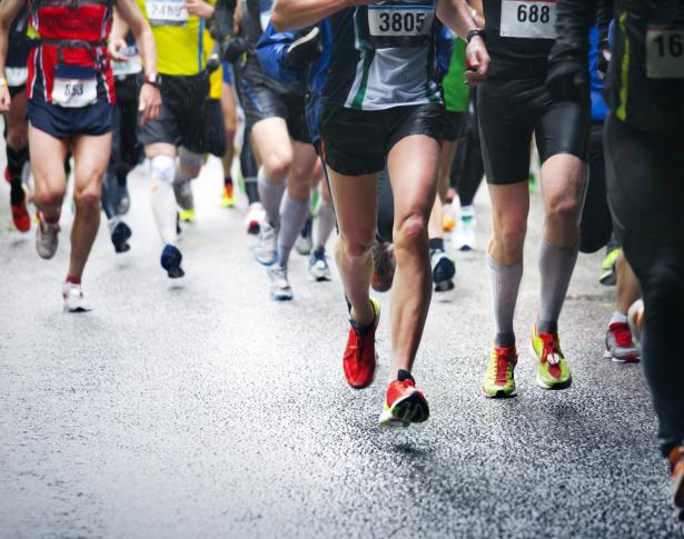 Corridori durante una maratona su strada bagnata.